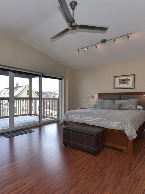 a large bed in the middle of a room with hardwood floors