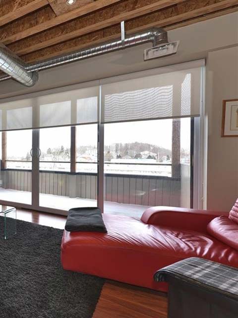 a red sofa sits in front of a deck