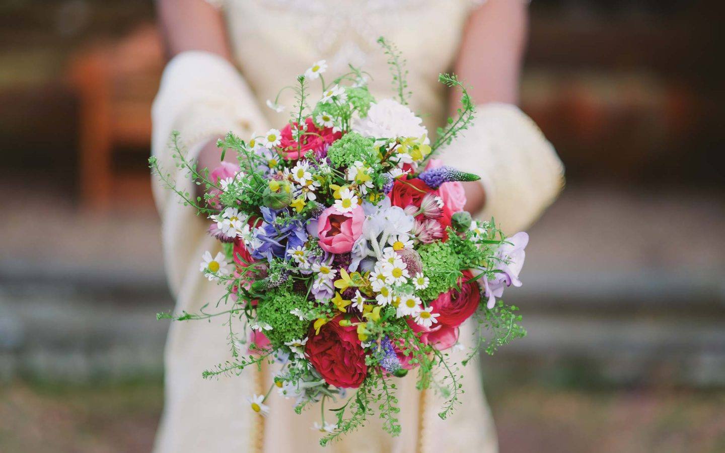 a close up photo of a bridal bouquet held by a bride
