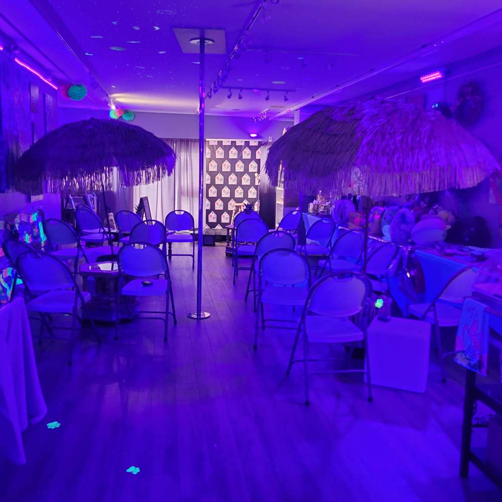 a room filled with lots of tables covered in purple lights