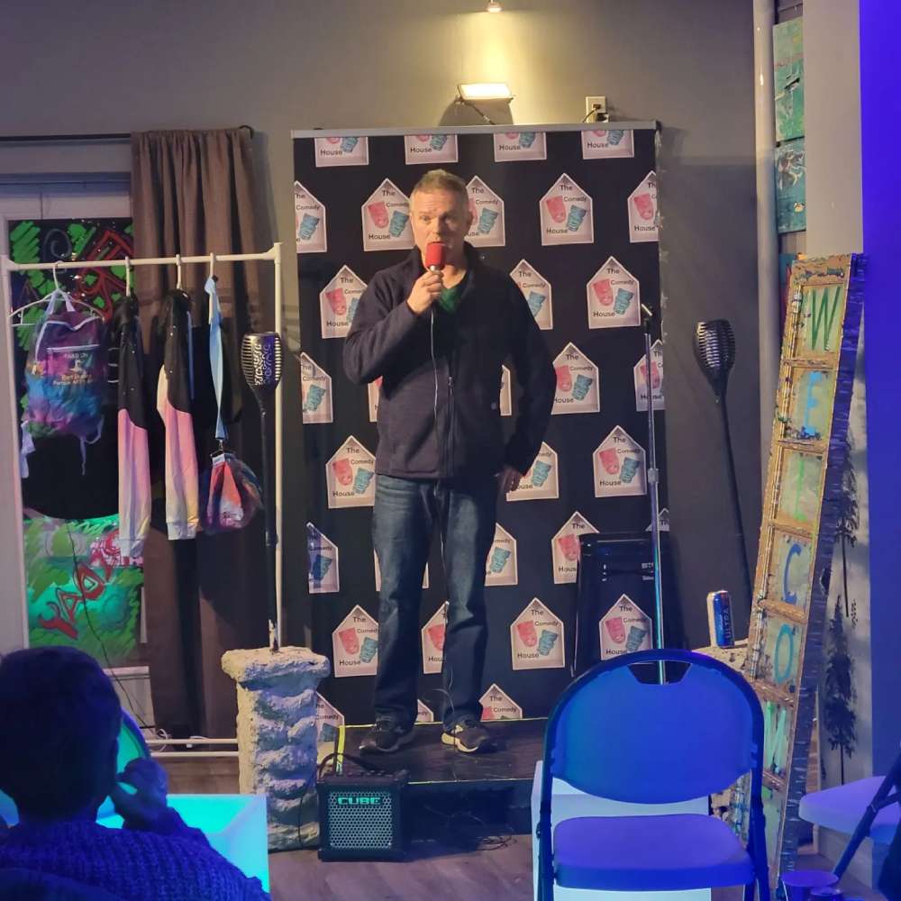 a man standing on a stage speaking into a microphone